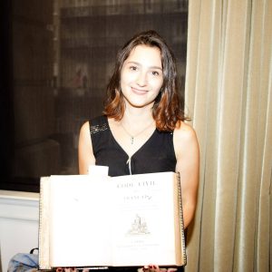 Noemie Le Colleter at the Louisiana Law Library in New Orleans, holding an original copy of the French Civil Code